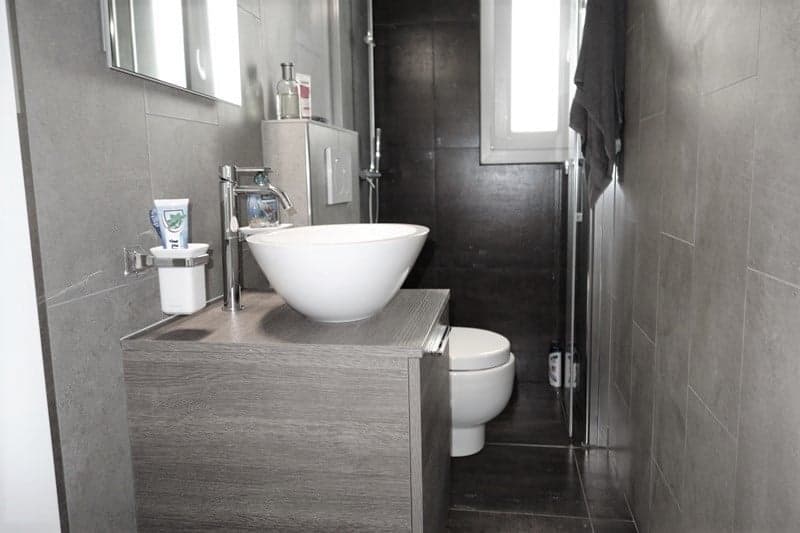 modern bathroom with a toilet, sink, mirror, and towel rack