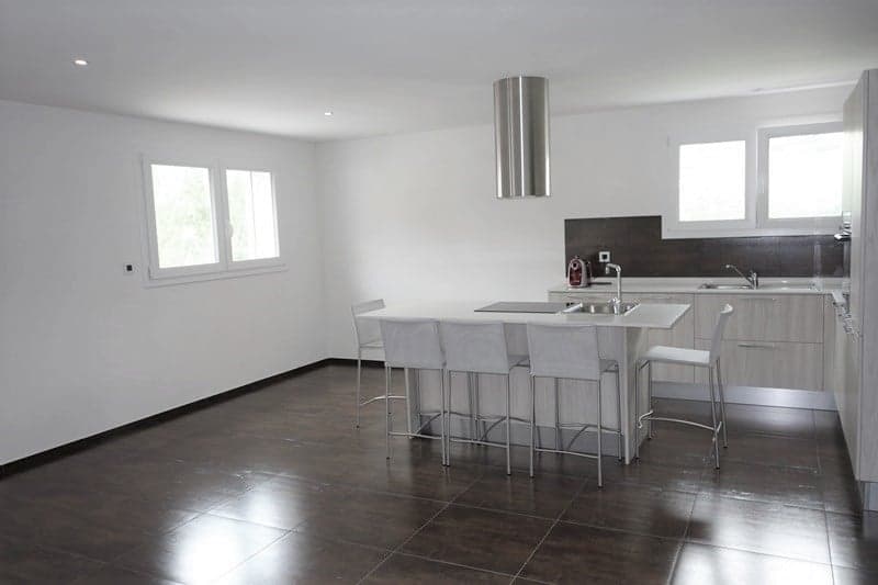modern kitchen, white walls, tile floor, island with bar stools, sink, stove, dishwasher, refrigerator