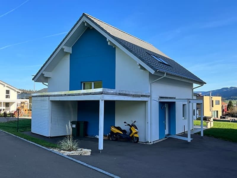 2-story house with white siding and blue accents, garage, parking space, and landscaped yard