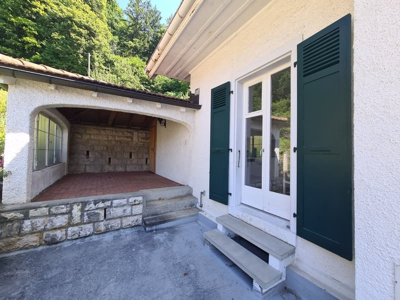 2-story house with a garage, white exterior walls, green shutters, and a stone entryway with a covered porch.