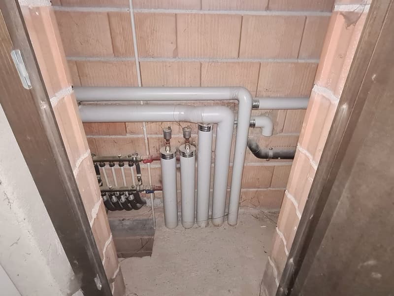 Exposed pipes and fixtures, brick walls, concrete floor