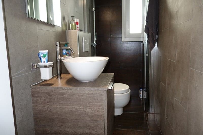 Modern bathroom with shower, white sink, and toilet