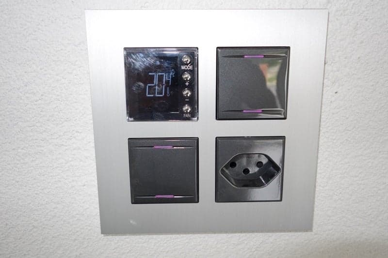 digital temperature display, two switches, one power outlet, mounted on wall