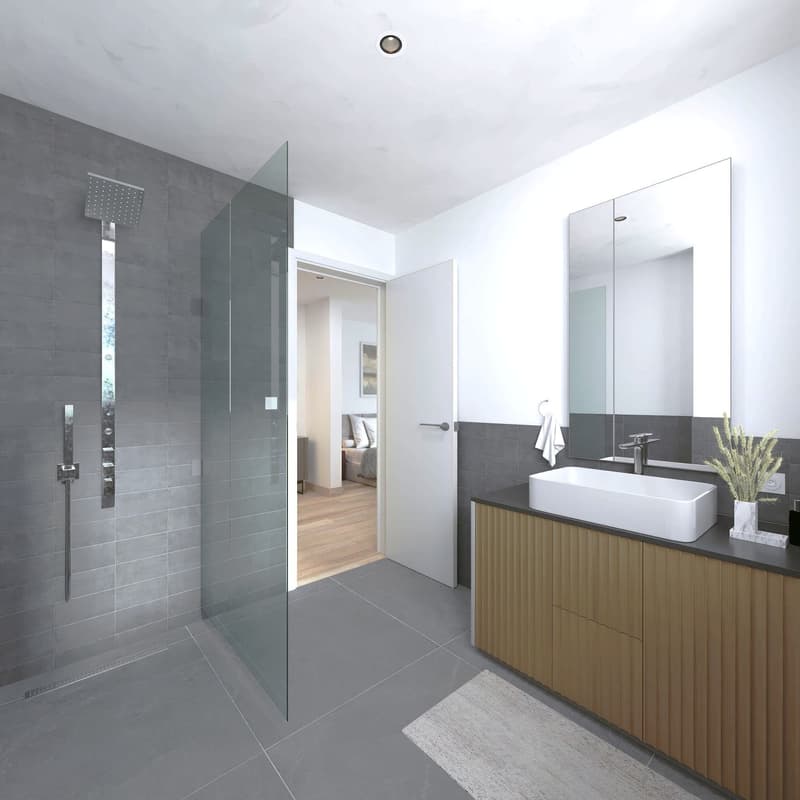 Modern bathroom, fully tiled, walk-in shower with glass door, white porcelain sink, chrome faucet, and a large mirror, white rug, and a plant