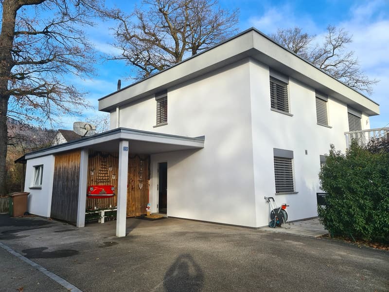 white, modern house, garage, car parked in front, trash bin, entrance area, large trees, clear sky