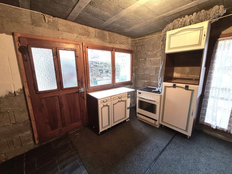 Room with stone walls, double doors, windows, stove, cabinets, kitchen