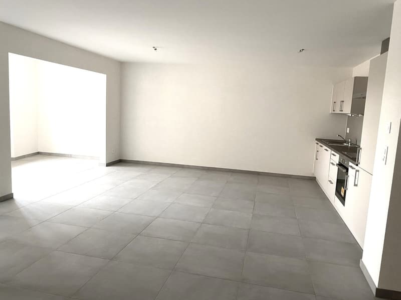empty room, tile flooring, white walls, open area, kitchen area with sink and oven