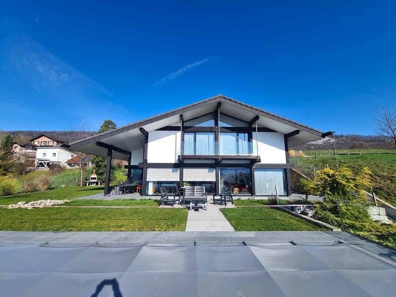 modern house, white exterior, glass windows, balcony, outdoor seating, concrete driveway, grassy area