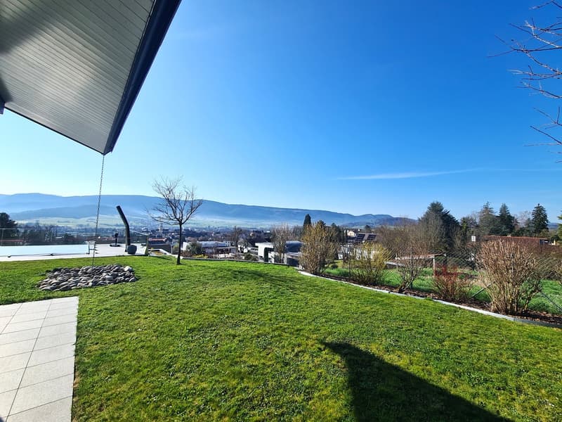 roof garden with green lawn, view of town and mountains