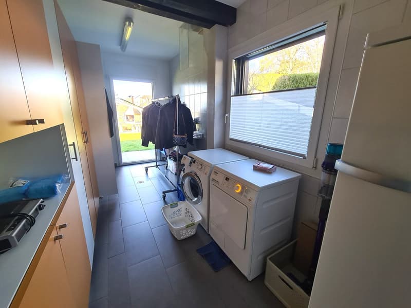 two washing machines, one dishwasher, cabinets, shelves, laundry baskets, cleaning supplies