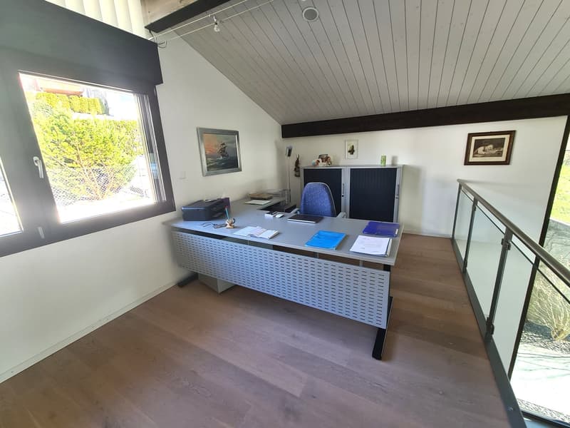desk, glass walls, blue chair, floor lamp, picture frames