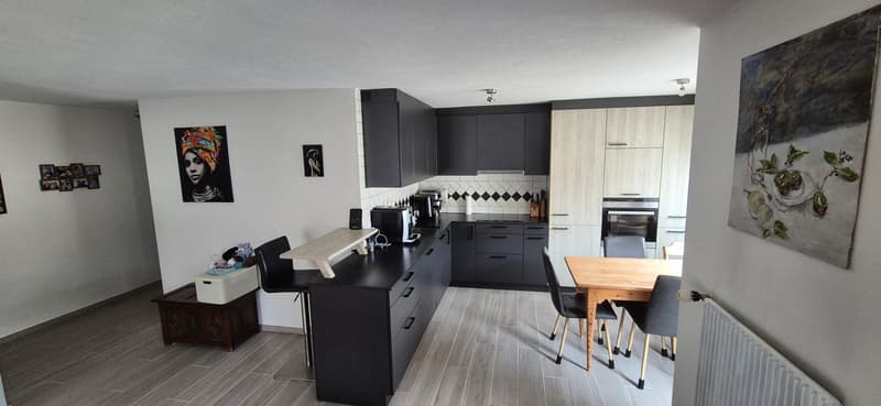 kitchen, black cabinets, wooden countertops, black chairs, wooden table, radiator, painting, black coffee machine