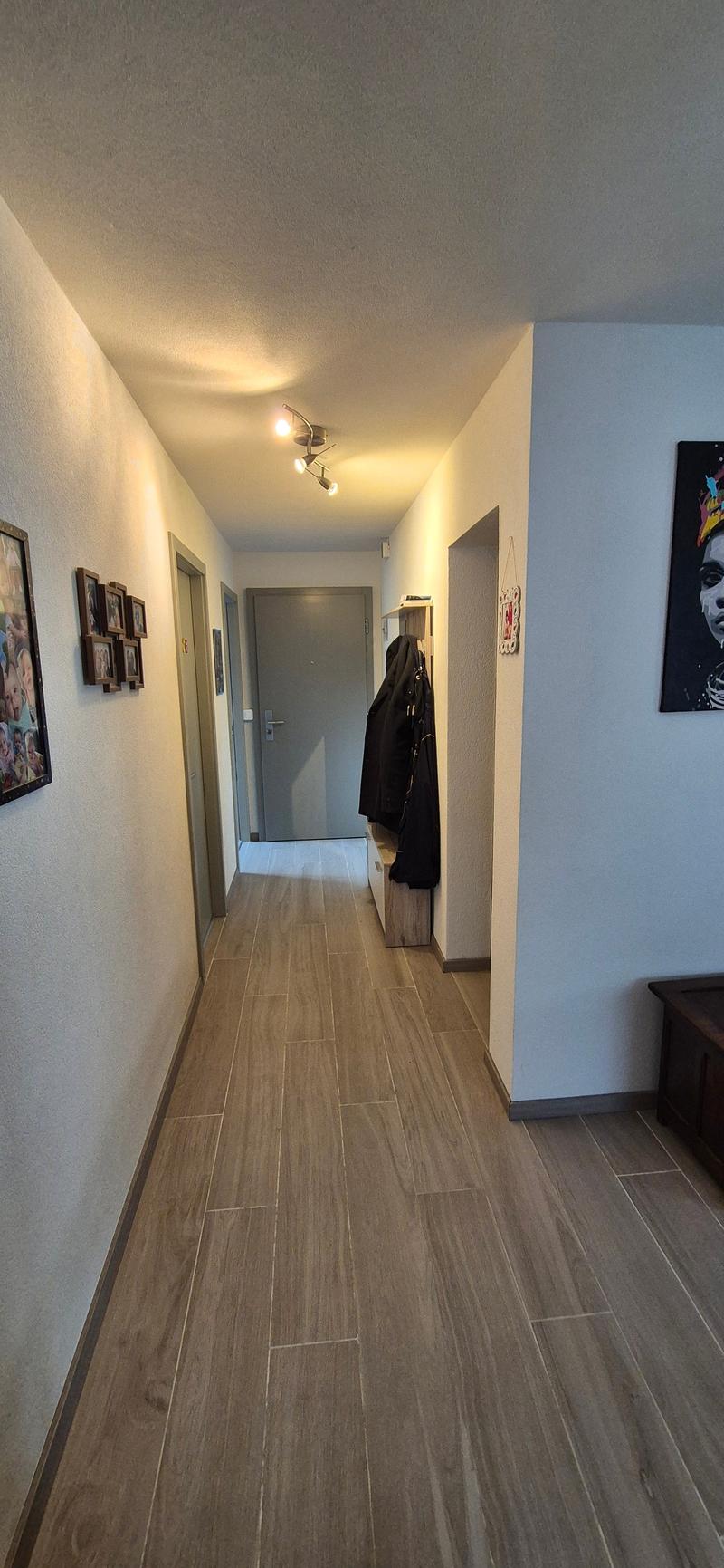 wooden floor, white walls, hallway, hanging coat, wall decoration, open door