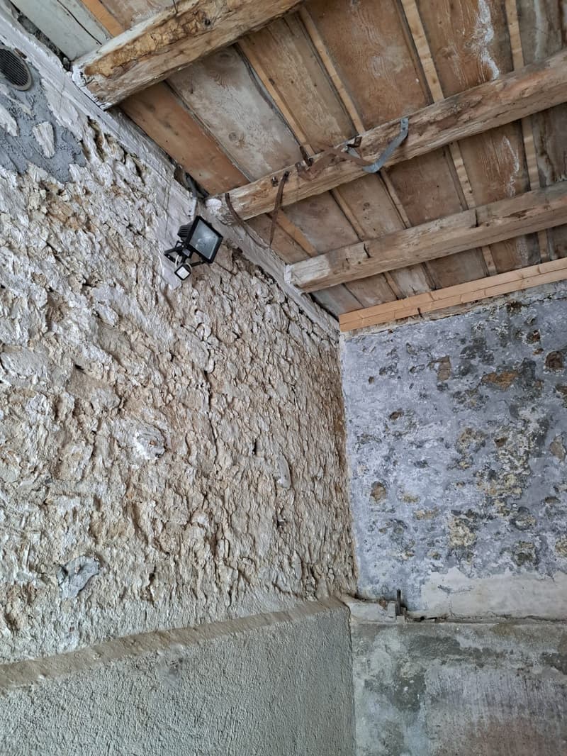 an old house interior, wooden ceiling, concrete wall, light fixture on wall