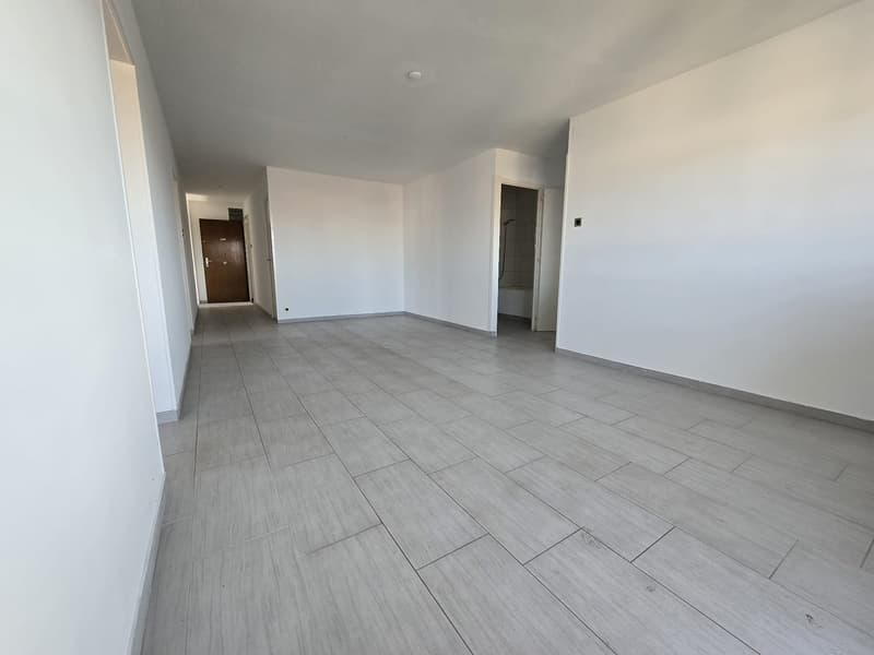 large empty hallway with wooden floor and white walls
