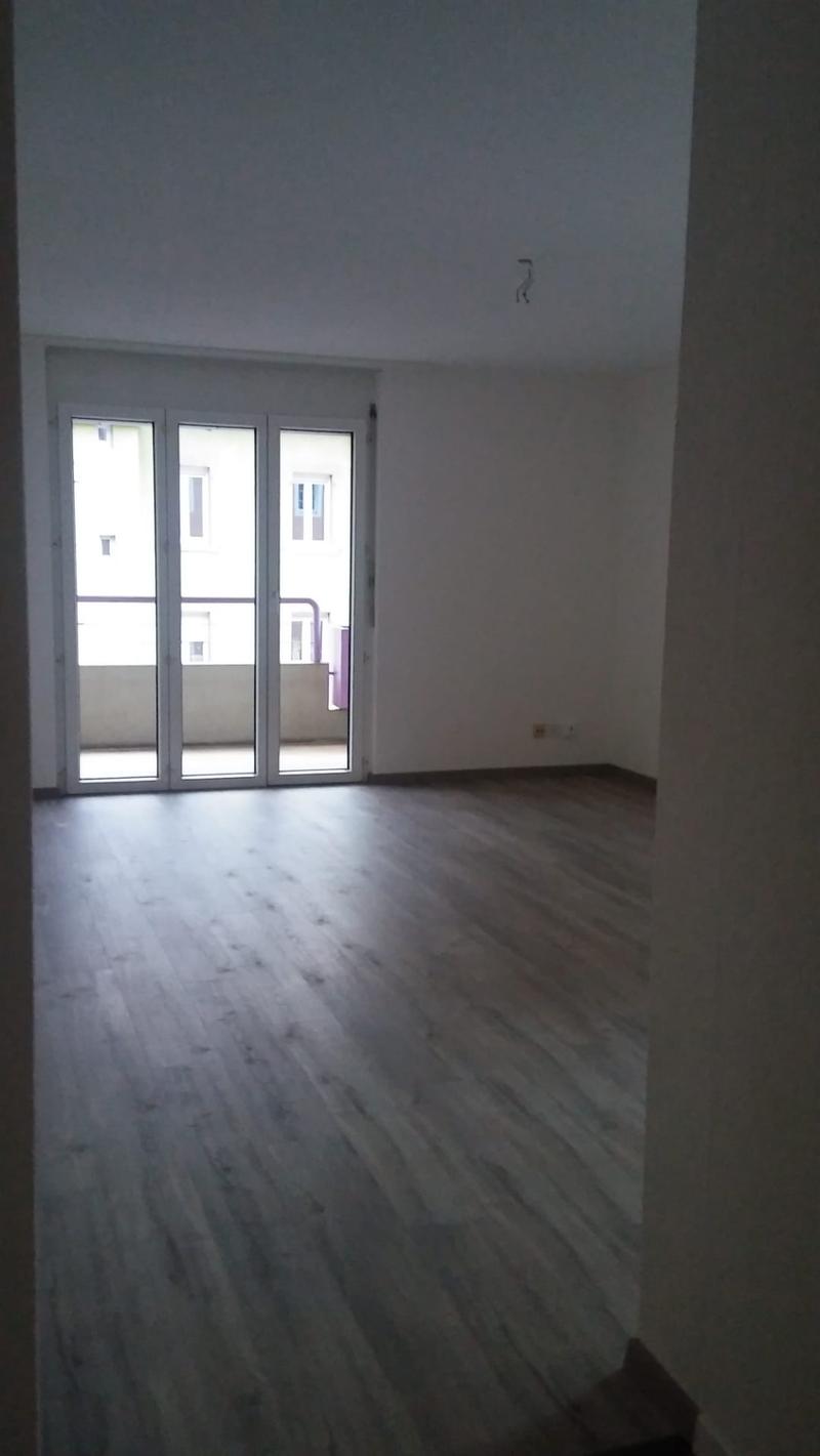 sliding glass door, wooden floor, white walls, balcony