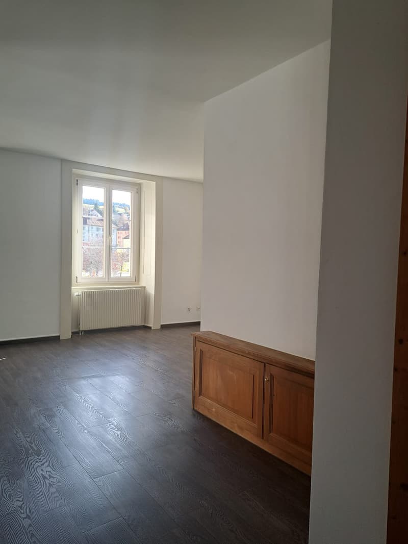 empty room, white walls, wooden floor, window with view, white radiator