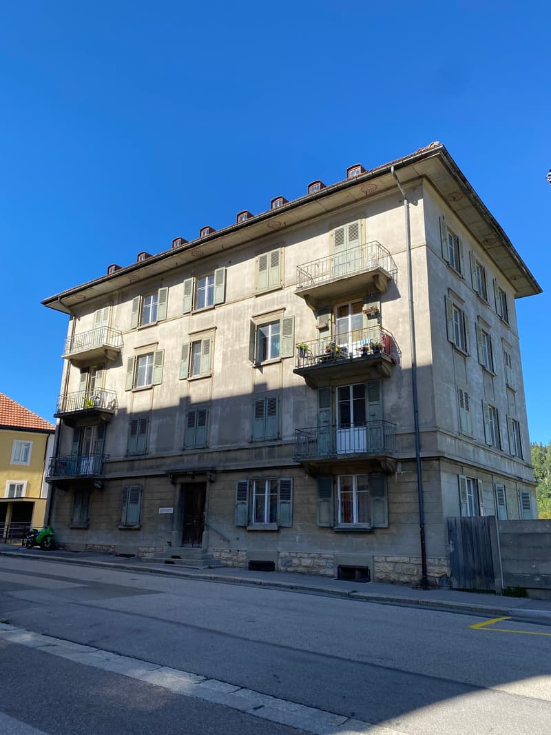 3 story building, balconies, windows, concrete foundation, street view