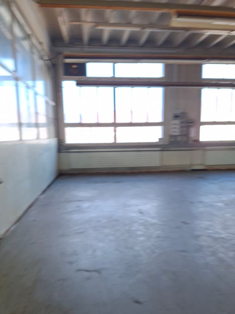 empty room, large windows, fluorescent lighting, white walls, concrete floor
