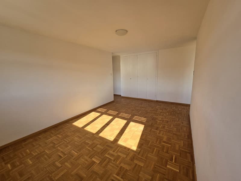 empty room, white walls, wooden parquet floor, built-in wardrobe