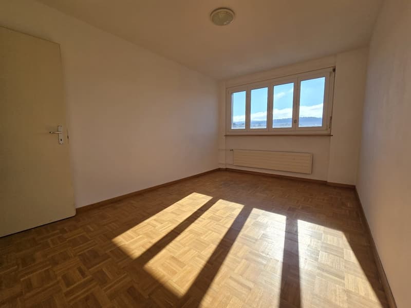 empty room, parquet floor, large window, white walls, light coming from window