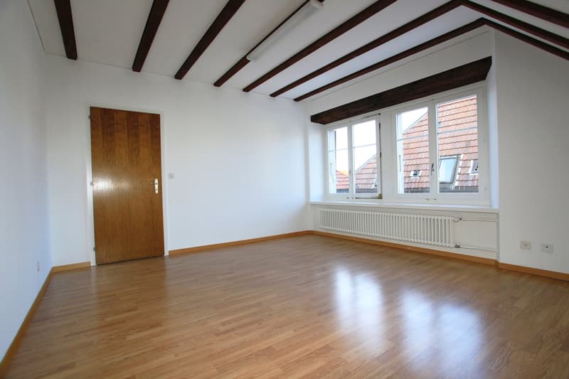 empty room, hardwood floor, wooden door, large windows, built-in radiator
