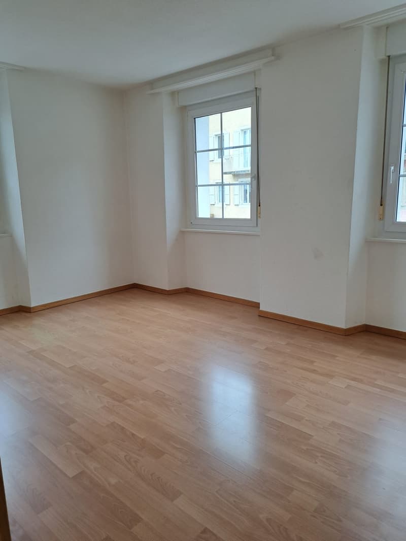 empty room, wooden floor, white walls, two windows, no furniture
