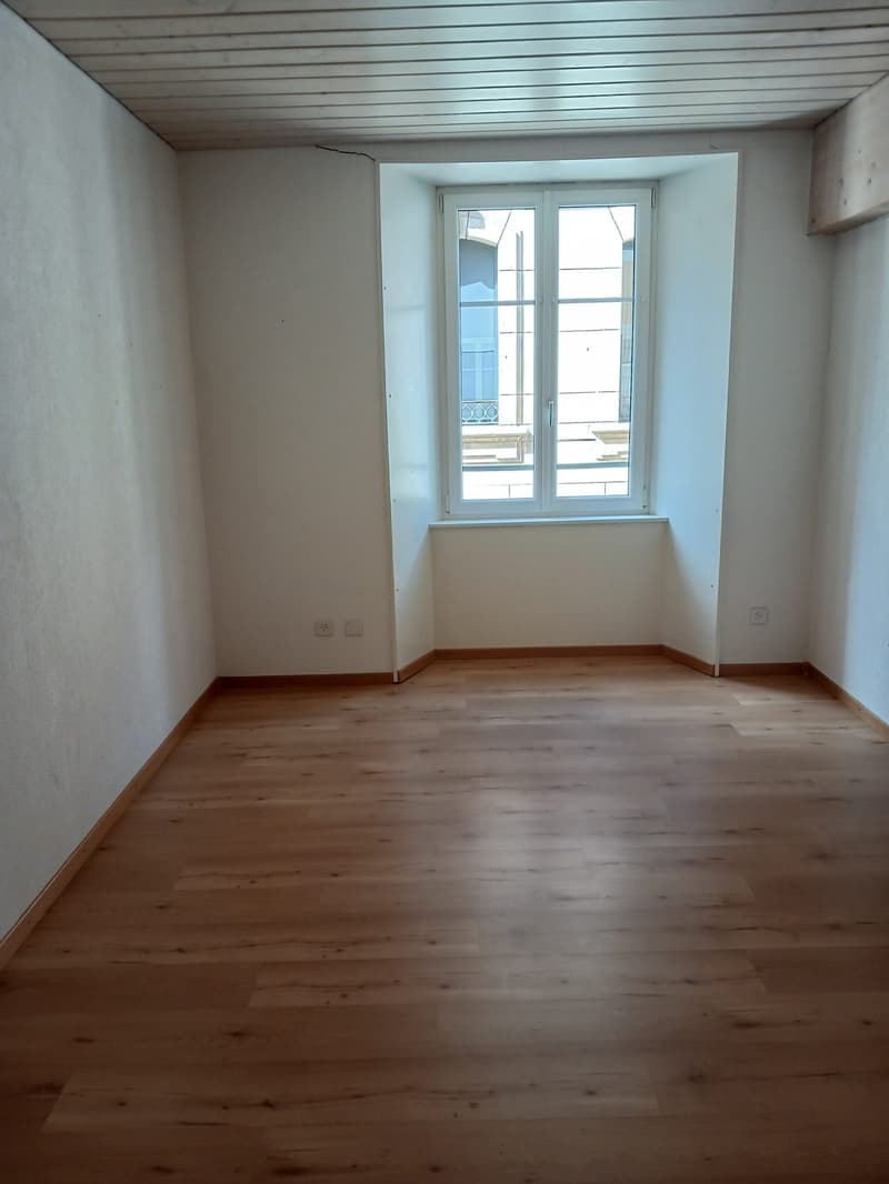 empty room, wooden floor, white walls, window, power outlets