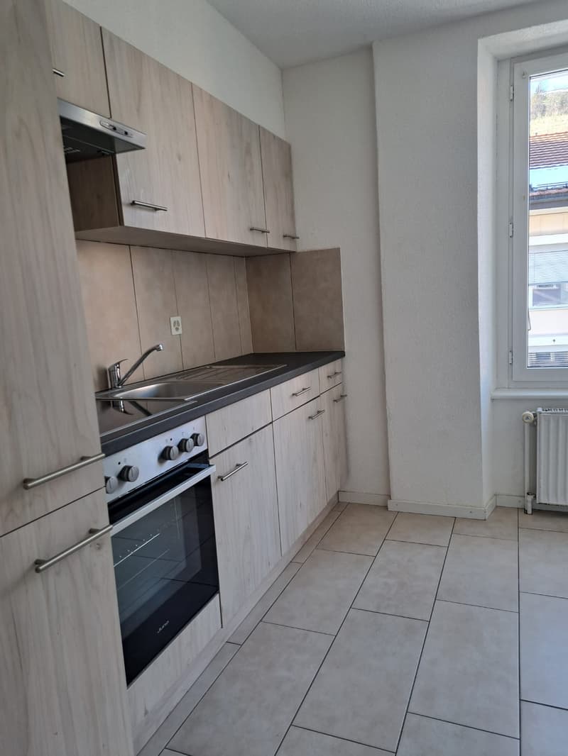 modern kitchen with wooden cabinets, stainless steel sink, gas stove, oven, tiled floor, window with view
