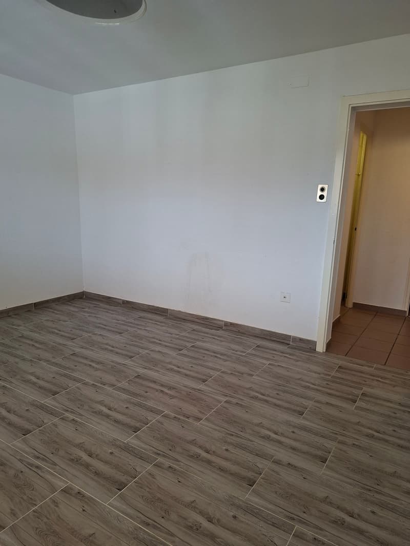 empty room, white walls, wooden floor, power outlet, door