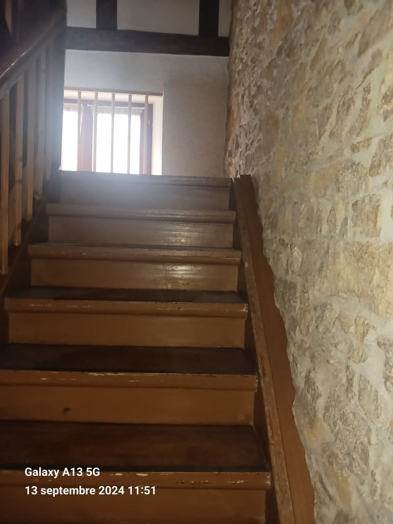 wooden staircase with a stone wall on the right side