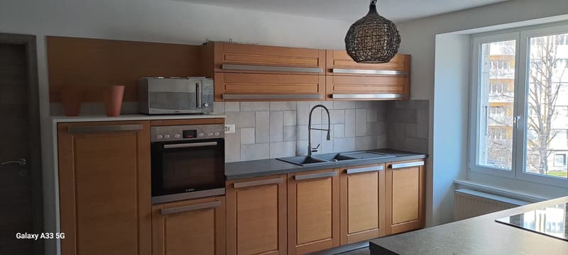 kitchen with wooden cabinets, oven, microwave, sink, faucet, window