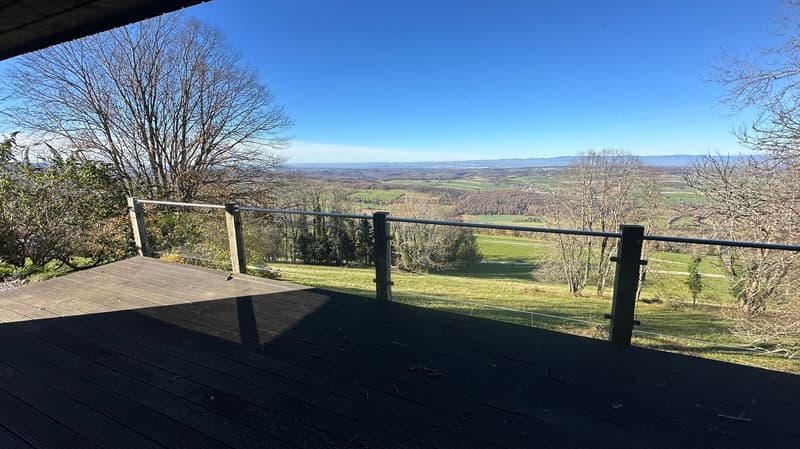 wooden deck, metal railings, panoramic view, clear blue sky, distant landscape