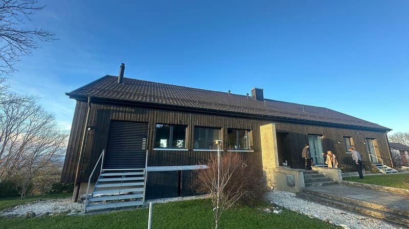2 story house, brown exterior, black window shutters, tiled roof, chimney, entrance, 2 stairs on the right