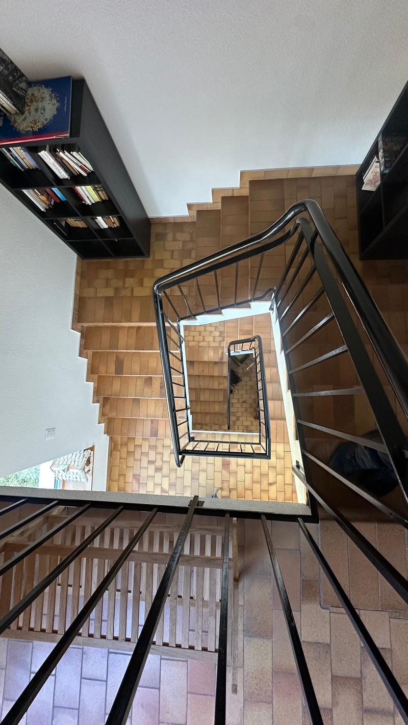 Inside view of a house's staircase with wooden floor and metal railing