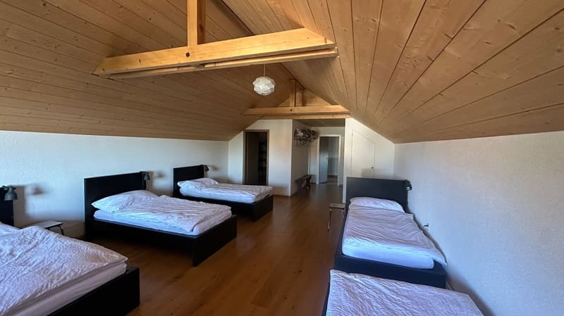 Bedroom with multiple beds and wooden ceiling
