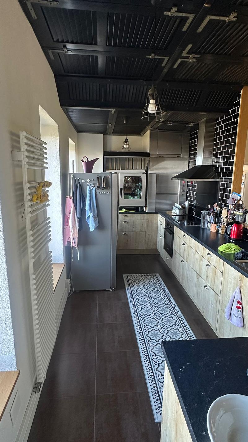 kitchen with tiled floor, wooden cabinets, black countertop, fridge, oven, stove