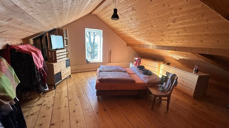 Bedroom with wooden flooring, bed, wardrobe, chair, TV on cabinet, window, pendant light