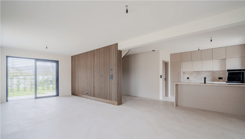 open space, large window, wooden wall, kitchen island, white cabinets