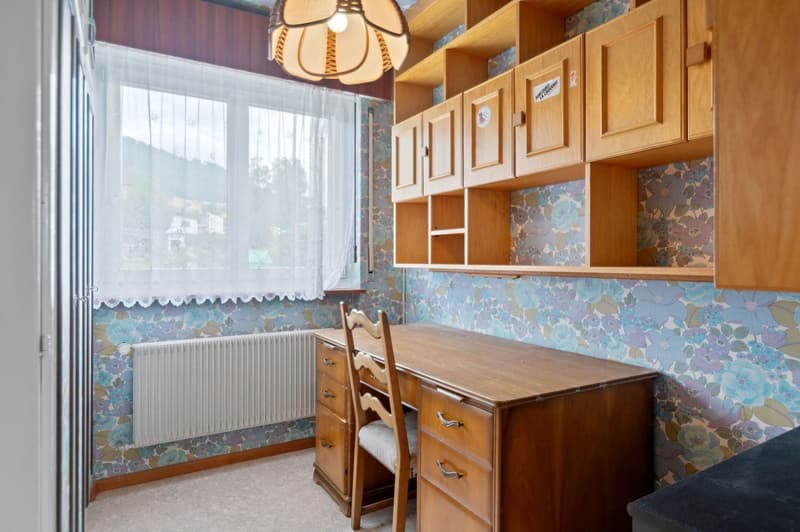Wooden cabinets, floral wallpaper, large window, wooden table and chairs, dishwasher