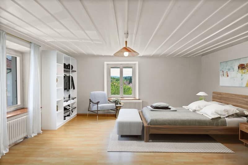 Spacious bedroom with wooden floor, white walls, large window with a view, built-in wardrobe, armchair, and a wooden bed frame with gray bedding
