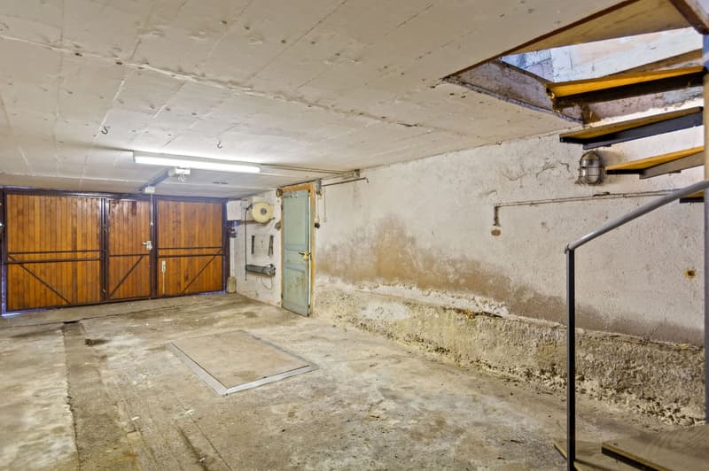 Concrete floor, wooden garage doors, wooden stairs, lamp