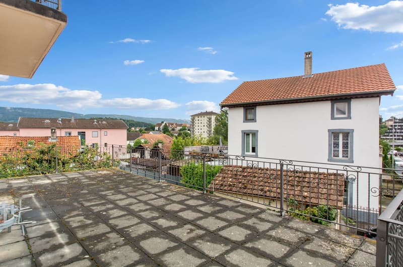 Terrace, metal railing, plants, tiled floor, surrounding houses, mountain