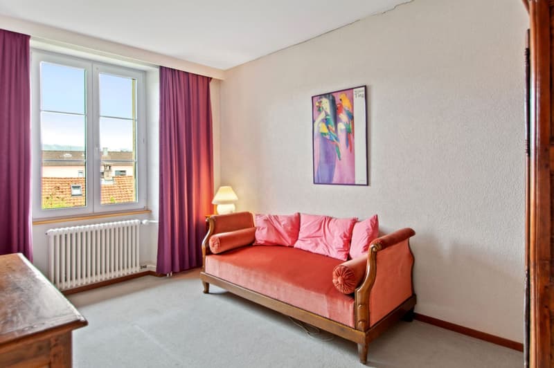 Single bed in the room with a large window and balcony, wooden desk and a radiator