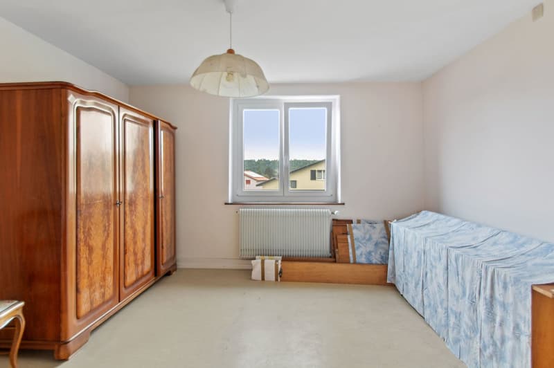 Large wardrobe, single bed, white walls, ceiling lamp, window