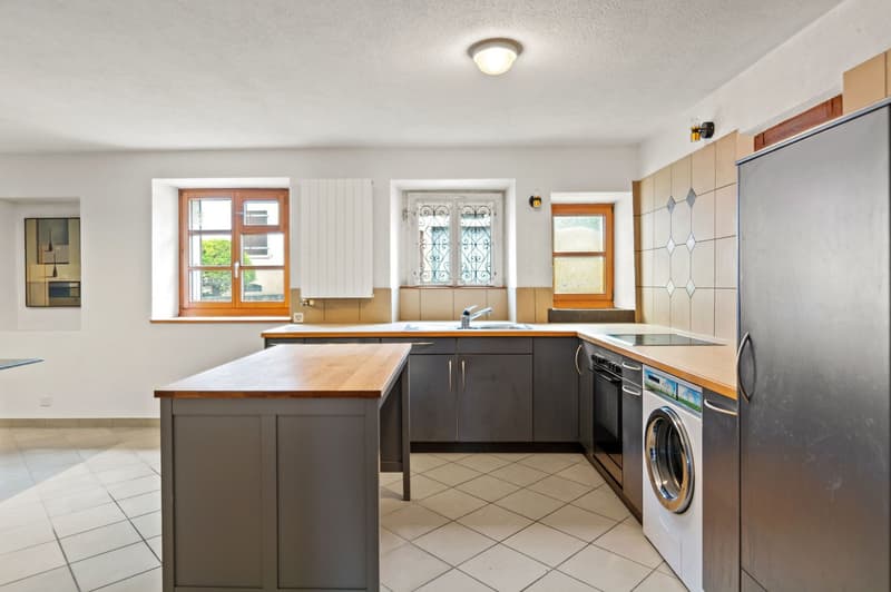 white tiles, white cabinets, wooden counter, sink, stove, fridge, washing machine, wooden windows