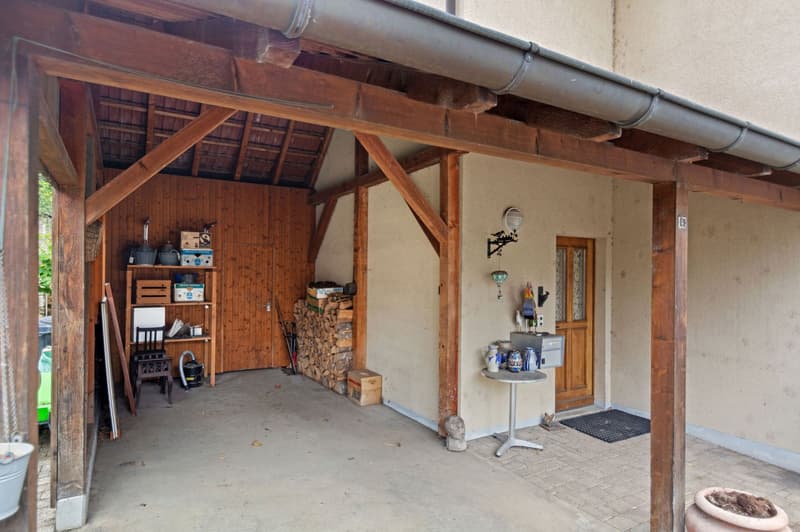 garage with wooden beams, wooden shelf, table, various tools and objects, wooden door