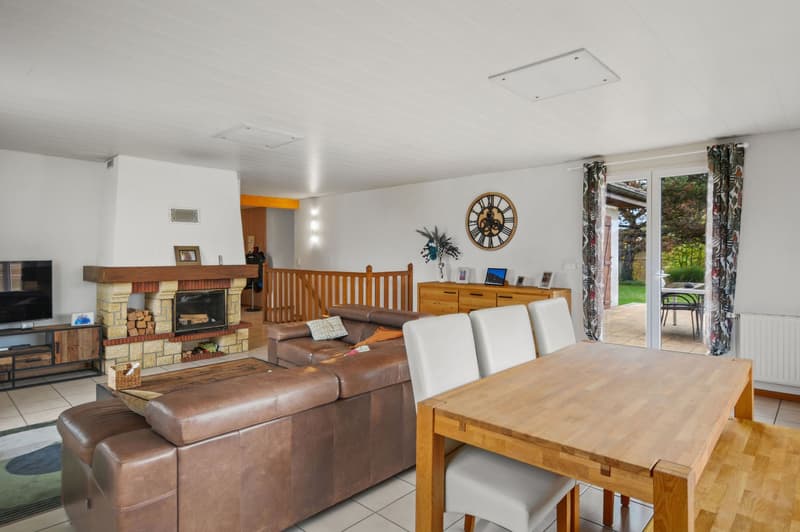 living room, fireplace, large windows, white walls, wooden dining table, white chairs, open terrace, wooden floor