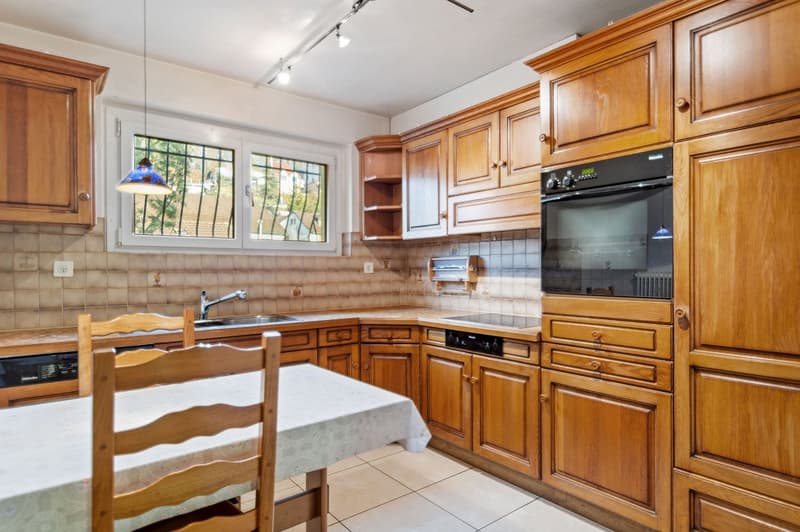 kitchen with wooden cupboards, table, chairs, oven, dishwasher, sink, lamp, ceramic tiles