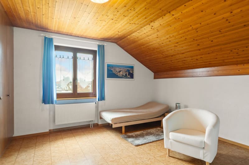 bedroom with single bed, single bed, radiator, wooden ceiling, white walls, windows with blue curtains, white chair, carpet, picture frame